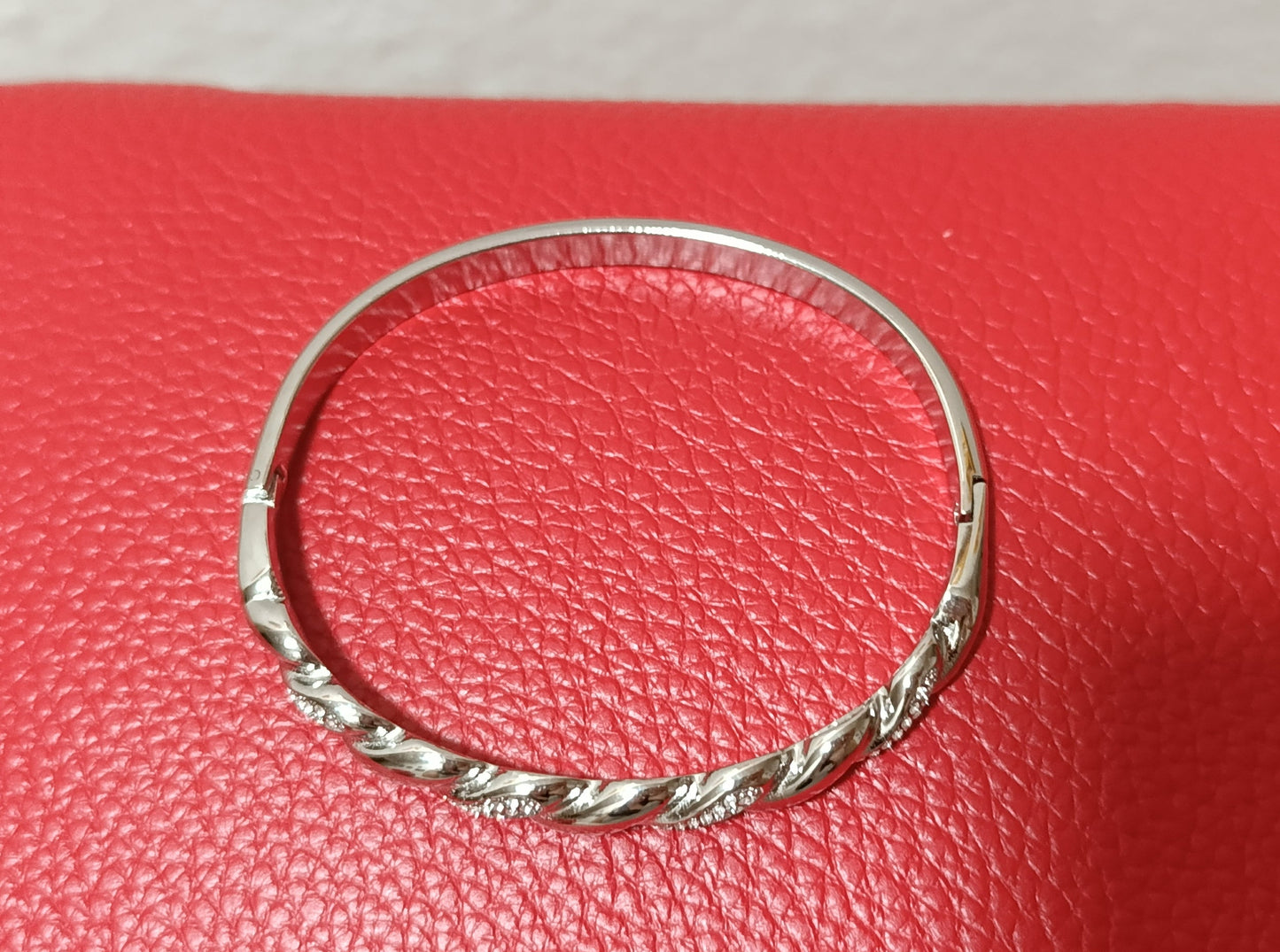 Ασημί χειροπέδα stainless steel με κυκλικό σχήμα, διάμετρο 6 εκ. και μπροστινό στριφτό σχέδιο με ζιργκόν.